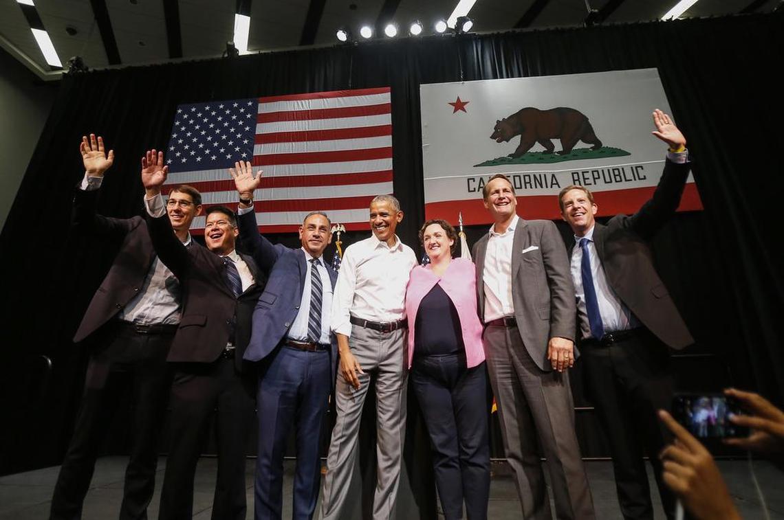 President Barack Obama, center, with congressional candidates, from left, Josh Harder, TJ Cox, Gil Cisneros, Katie Porter, Harley Rouda and Mike Levin wave to supporters Saturday in Anaheim.