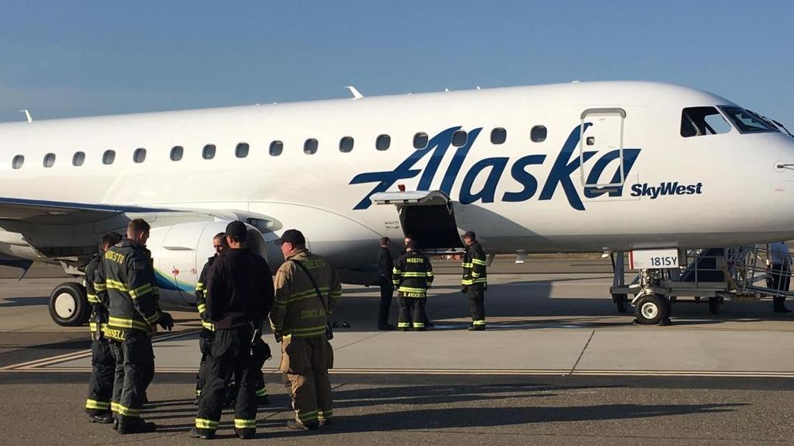 Firefighters standing near an Alaska Airlines jet that was forced to make an emergency landing at the Modesto Airport Sunday (April 9, 2017).