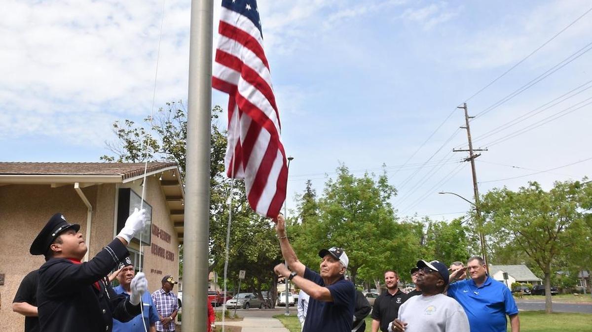 Modesto firefighter Jose Valenzuela, left, and Mike Stavrakakis raise the new flag Friday afternoon, April 8, 2016, at the King-Kennedy Memorial Center in Modesto, Calif. Longtime west Modesto resident and Navy veteran George Russell looks on at right front.
