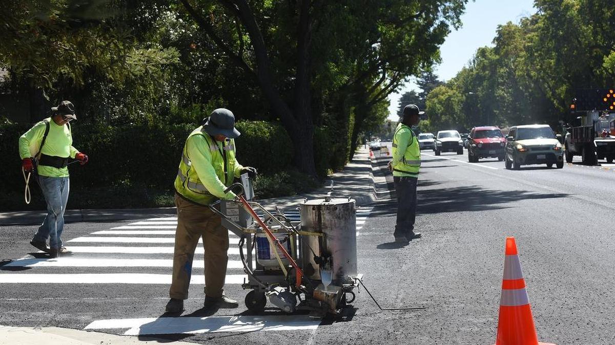 
Jaime Leal, center, with Sierra Traffic Markings Inc. stripes a crosswalk at Exeter and College avenues on Tuesday afternoon in Modesto. The crew will re-mark College avenue from Needham Street through Briggsmore Avenue as part of a road diet in the area.
