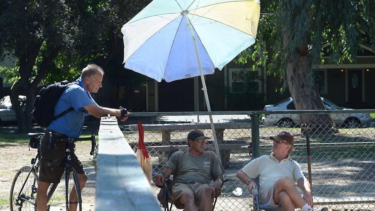
From left to right, Kurt Osterholm, Marshall Camarena and Greg Krigbaum beat the heat under an umbrella at the horseshoe pits in Enslen Park in Modesto on July 29.
