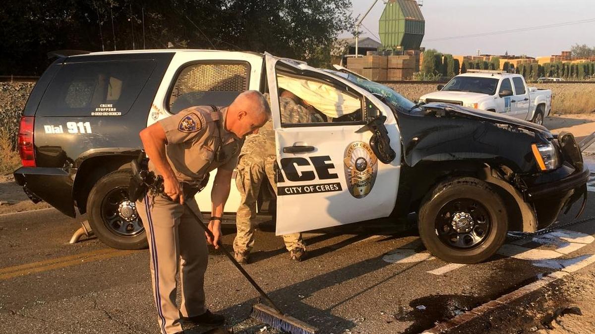 California Highway Patrol Officer Bryce Disch sweeps up glass and debris from the roadway after a predawn, single-vehicle crash involving a Ceres police officer in Oakdale on Thursday, Aug. 18, 2016. Disch said the Ceres officer was driving west on Sierra Road and struck a utility pole guy wire alongside the road. The vehicle literally climbed the wire, snapping it, and then flipped over.
