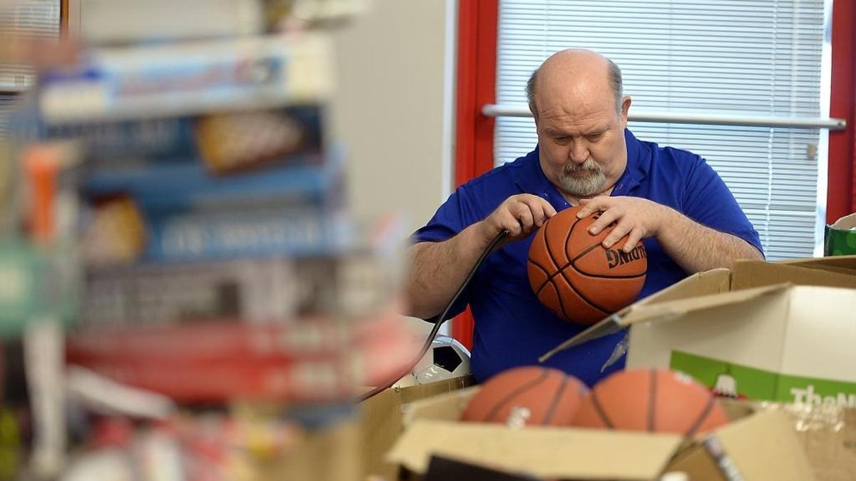 Maj. Kyle Trimmer with the Salvation Army inflates toy balls Monday afternoon, Nov. 30, 2015, at a space in Salida where volunteers sort and bag toy donations.