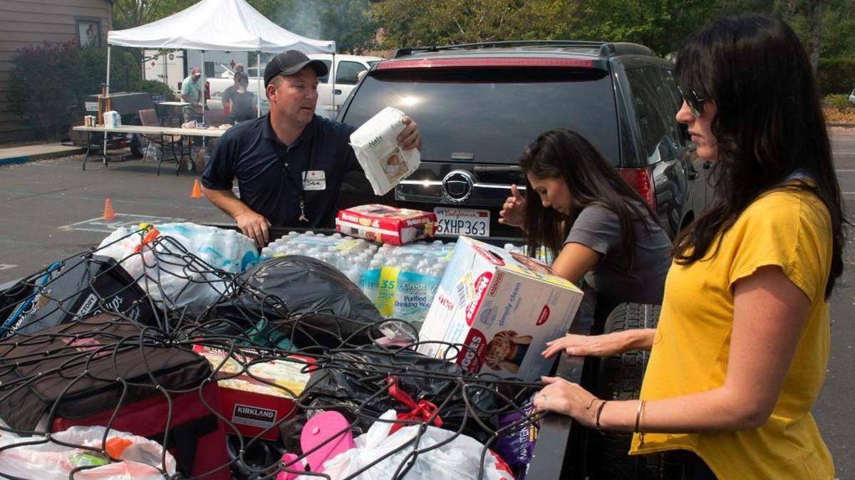 
Volunteer Steve Blum examines donated items supplied by Sarah Nelson-Greco, right, and Andrea Rollins-Bell at a Butte fire evacuation center at Good Samaritan Church in Valley Springs today.
