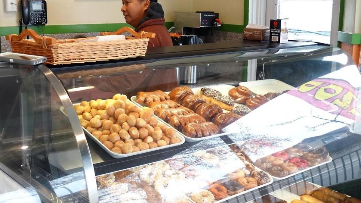 Friends Sam Kang and T.J. Nguyen, both of Merced, are partners in Vegan Donuts Gelato, which opened about five weeks ago on Needham Street in downtown Modesto, Calif. Their plant-based products include no diary products or eggs. Here, Kang works behind the doughnut case Tuesday (01-17-17) while talking with customers.