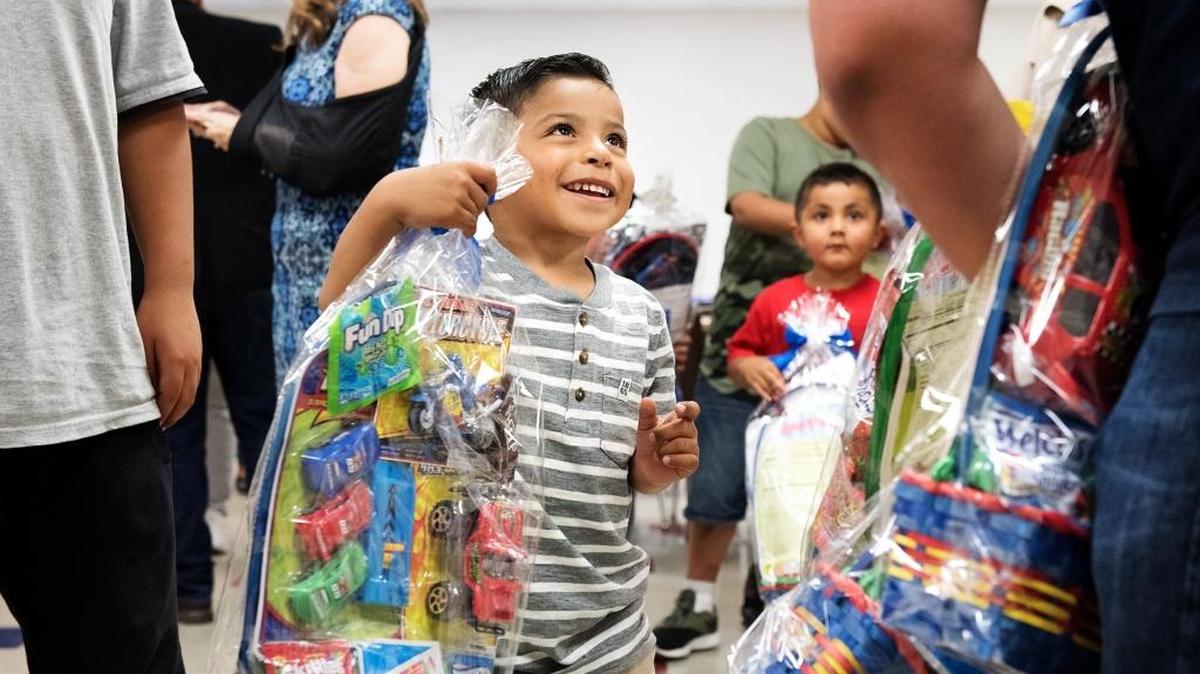 Everavo Morelos, 4, from gets a Easter basket from volunteer Jimmy Mata at the Salvation Army's Red Shield Center in Modesto, Calif., on Wednesday, March 28, 2018.