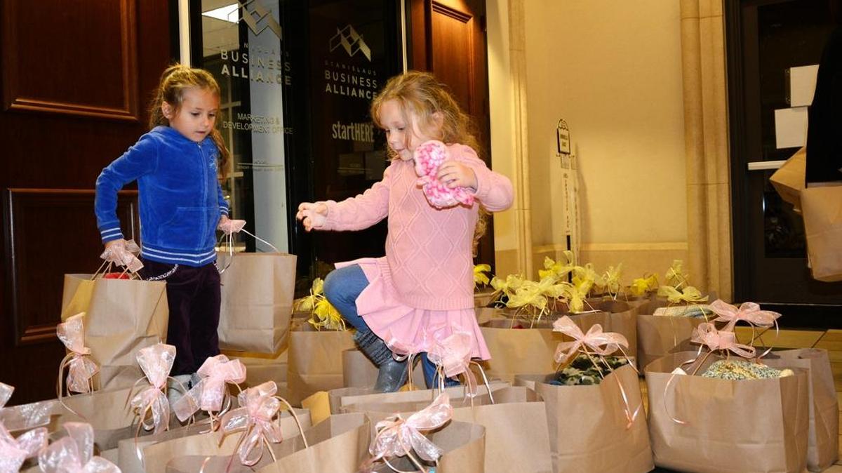 Sisters Maya Galan, 5, and Sofia Galan, 3, help carry bags of baby clothes from the Modesto City Council chambers on Tuesday, Nov. 10, 2015. Four charities received the donations for Second Chance Week, a nationwide public awareness campaign that promotes recycling of items.