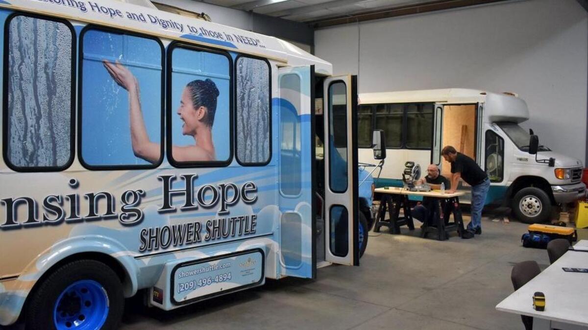 Brothers Brad and Doran Ott work on the second Cleansing Hope Shower Shuttle in a warehouse on South Santa Cruz Avenue in Modesto, CA, on May 23, 2017. In the foreground is the original, which has provided hot showers to thousands of impoverished and homeless in Modesto since August of 2016.