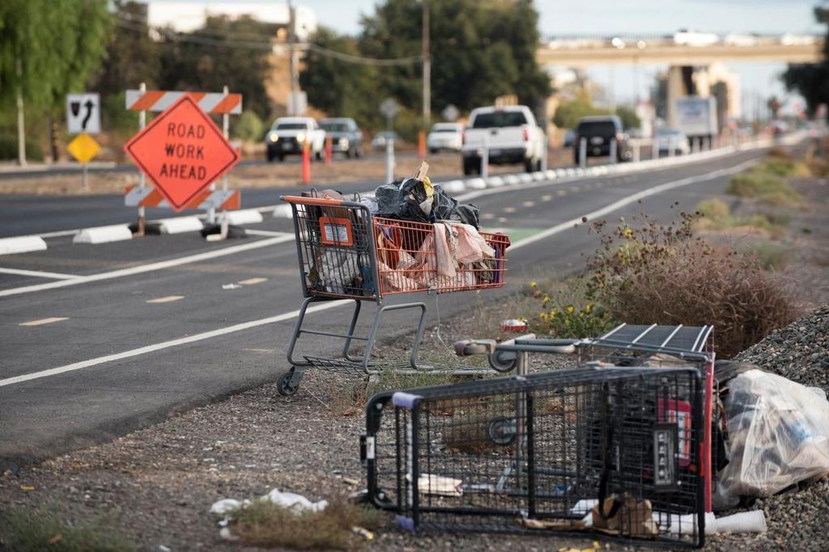 Garbage and remnants of homeless camps are discarded along 9th Street after a crew removed oleander bushes in Modesto, Calif., on Thursday, Nov. 9, 2017.