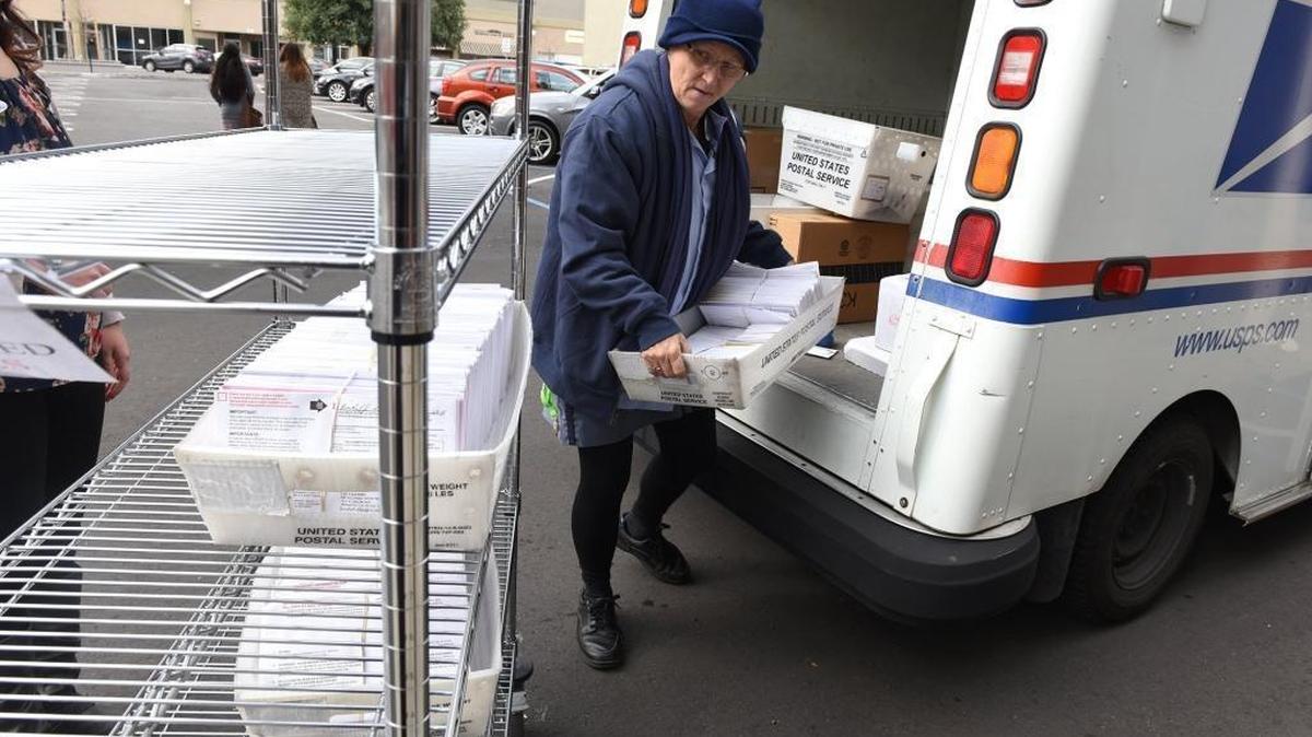 Postal carrier Rhonda Parker unloads mail-in ballots for the Modesto mayoral runoff in February 2016.