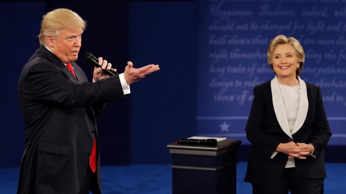 Republican presidential nominee Donald Trump speaks with Democratic presidential nominee Hillary Clinton during the second presidential debate at Washington University in St. Louis, Sunday, Oct. 9, 2016.