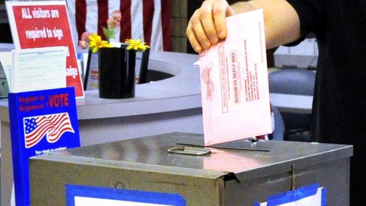 A voter drops his absentee ballot in the ballot box at the Registrar of Voters office in Modesto in 2012.