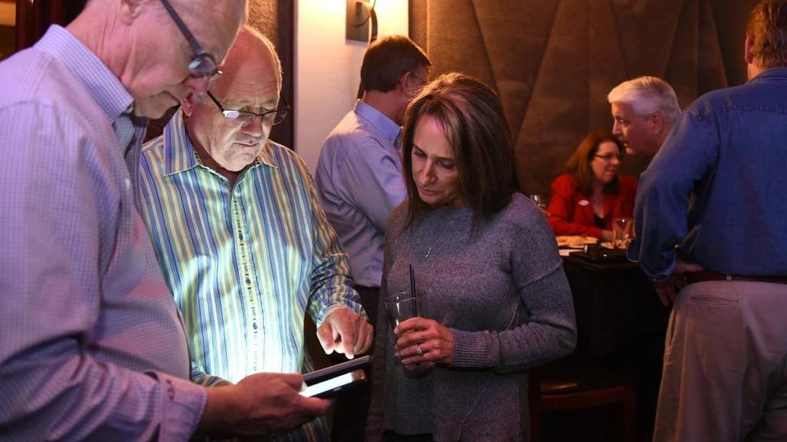 From left, David Wright, and Bill and Cathy Zoslocki look at election results at a Measure L party Tuesday night at Vito’s in downtown Modesto.