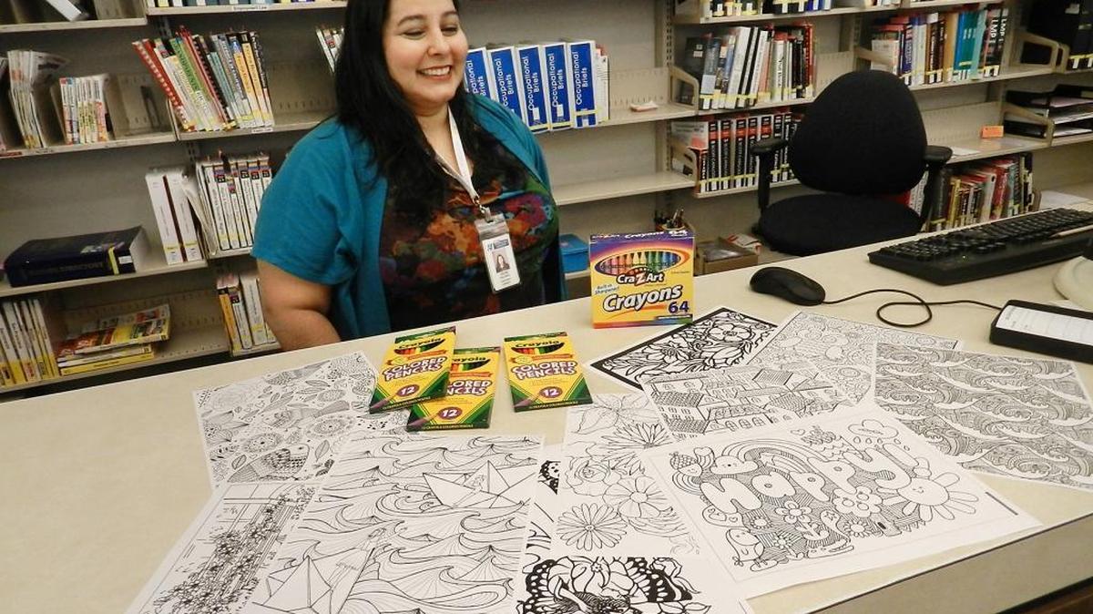 
A variety of coloring sheets sit on the counter in front of reference librarian Vicki Salinas on Tuesday morning at the Modesto library downtown. 
