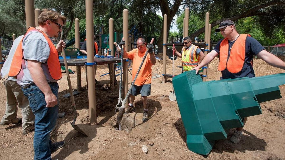 Josh Boyd, left, Paul Crabill, center, and Jerod Havel, right, and other members of Leadership Modesto are replacing the fire damaged play structure at Graceada Park in Modesto, Calif., Saturday, June 9, 2018.