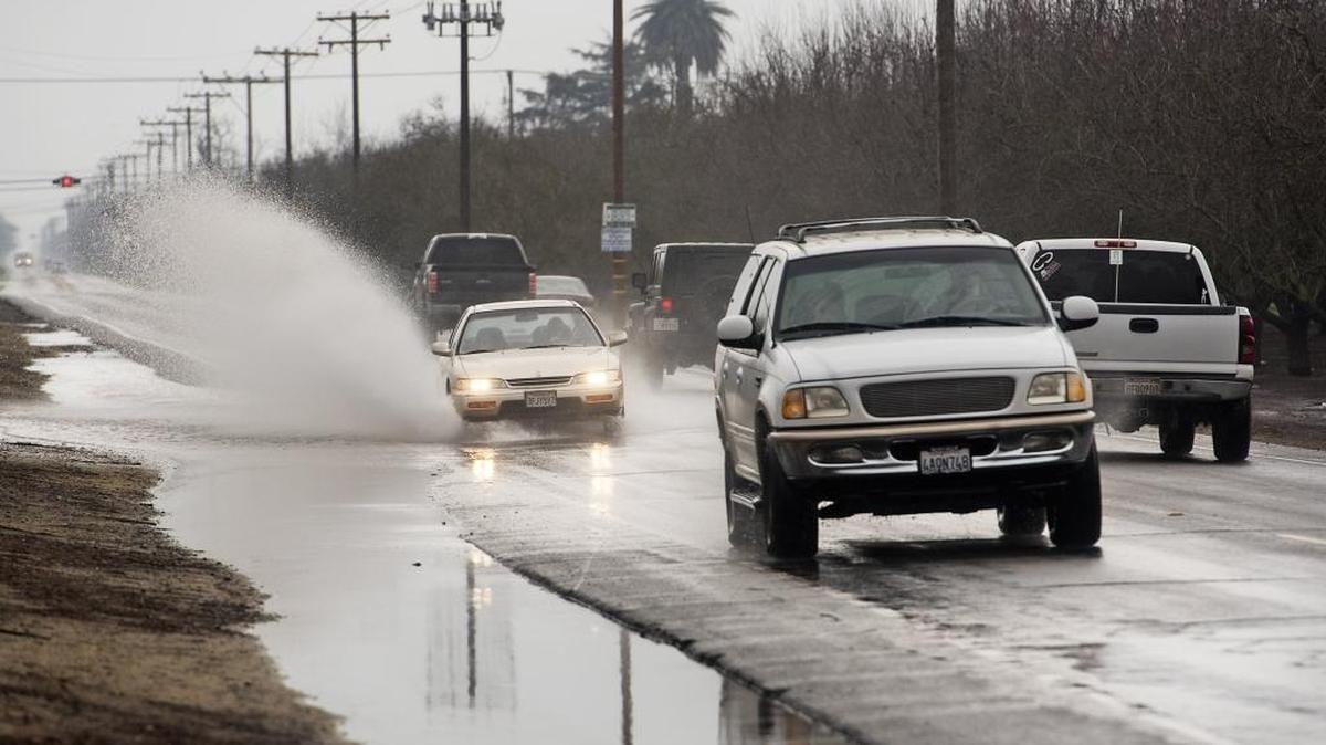 A car drives through a partially flooded stretch of Carpenter Road in Modesto, Calif., on Saturday, Jan. 7, 2017.