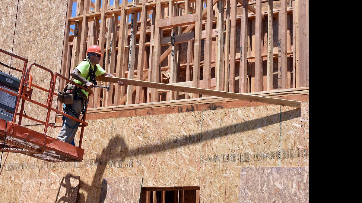 
Brian Marinus with Blades General Contracting lifts a board into place as he puts up a wall Thursday afternoon at the Tower Park Senior Housing complex under construction at 17th and G streets in downtown Modesto. The project is nine weeks into framing.
