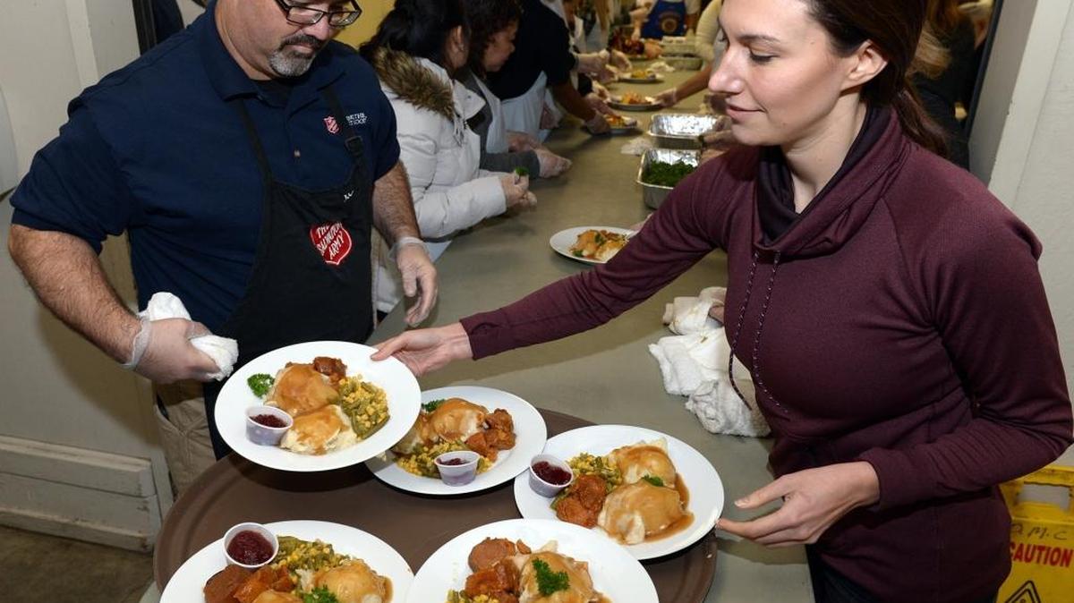 J.C. Curtis. left, and Kelsie Costa put plates on trays to be carried out to diners at the Thanks-for-Giving dinner at Modesto Centre Plaza.