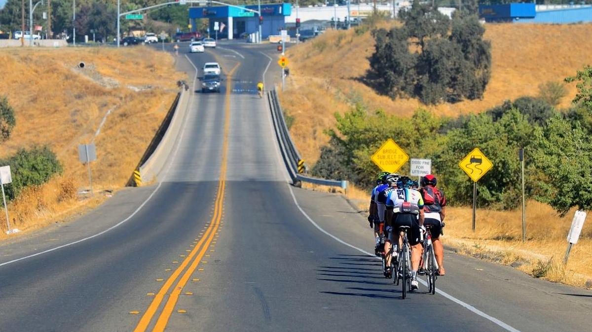 Bike riders approach the Hickman Road bridge over the Tuolumne River.