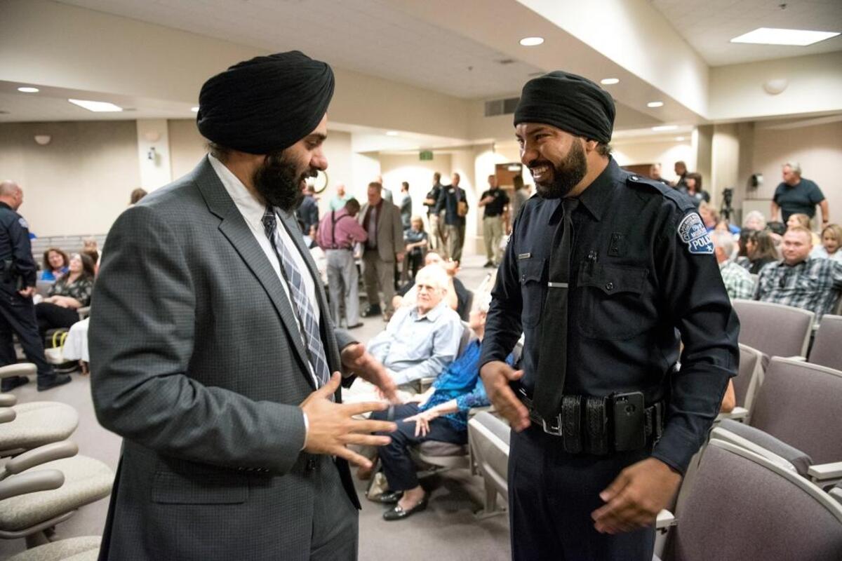Modesto City Council member Mani Grewal greets Varinder Khun Khun, right, before a swearing-in ceremony at Modesto city council chambers in Modesto, Calif., on June 14, 2016. Khun Khun, the first Sikh police officer in the history of the Modesto Police Department.
