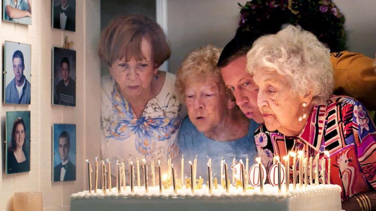 Hip-hop artist Macklemore (2nd from right) and his grandmother, Helen Schott (right), blow out her birthday candles. They are shown in a still from his new music video “Glorious.” The city of Modesto in California is the backdrop for the video, which shows Macklemore spending the day with his grandmother at various locations around town. It was shot over a few days over mid-June.