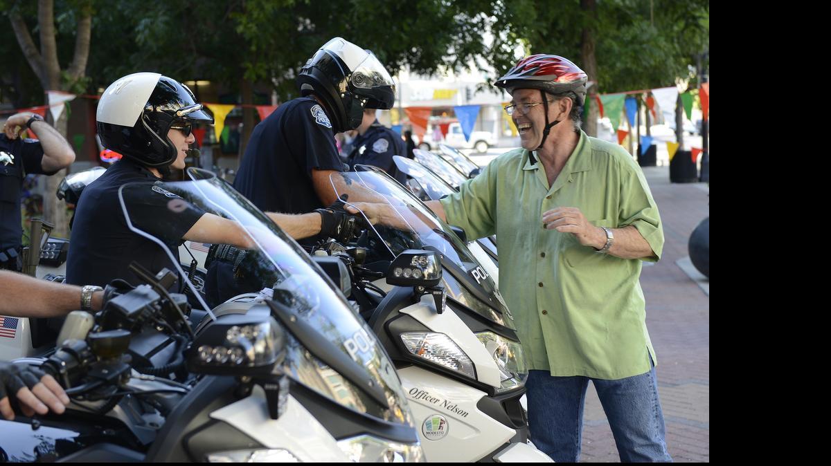 
Modesto’s Mayor Garrad Marsh greets Modesto police Officer Scott Nelson at the 2014 Bike to Work event at Tenth Street Plaza.
