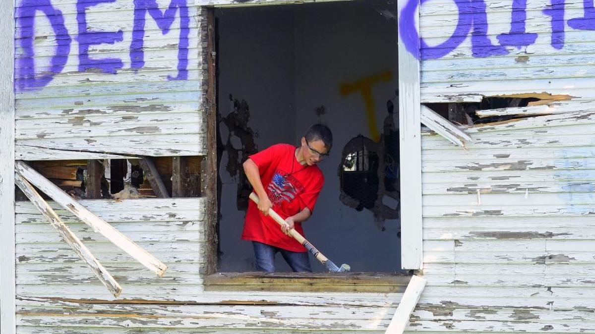 Gilbert LoBue swings a hammer on Saturday, March 19, 2016, at a house in Denair, Calif., as part of Project Demolition Tumor to raise money for Eli LoBue to get surgery to address a brain tumor.