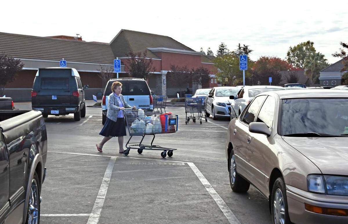 A shopper makes her way to her car in the Walmart parking lot on Friday on McHenry Avenue in Modesto, Calif.