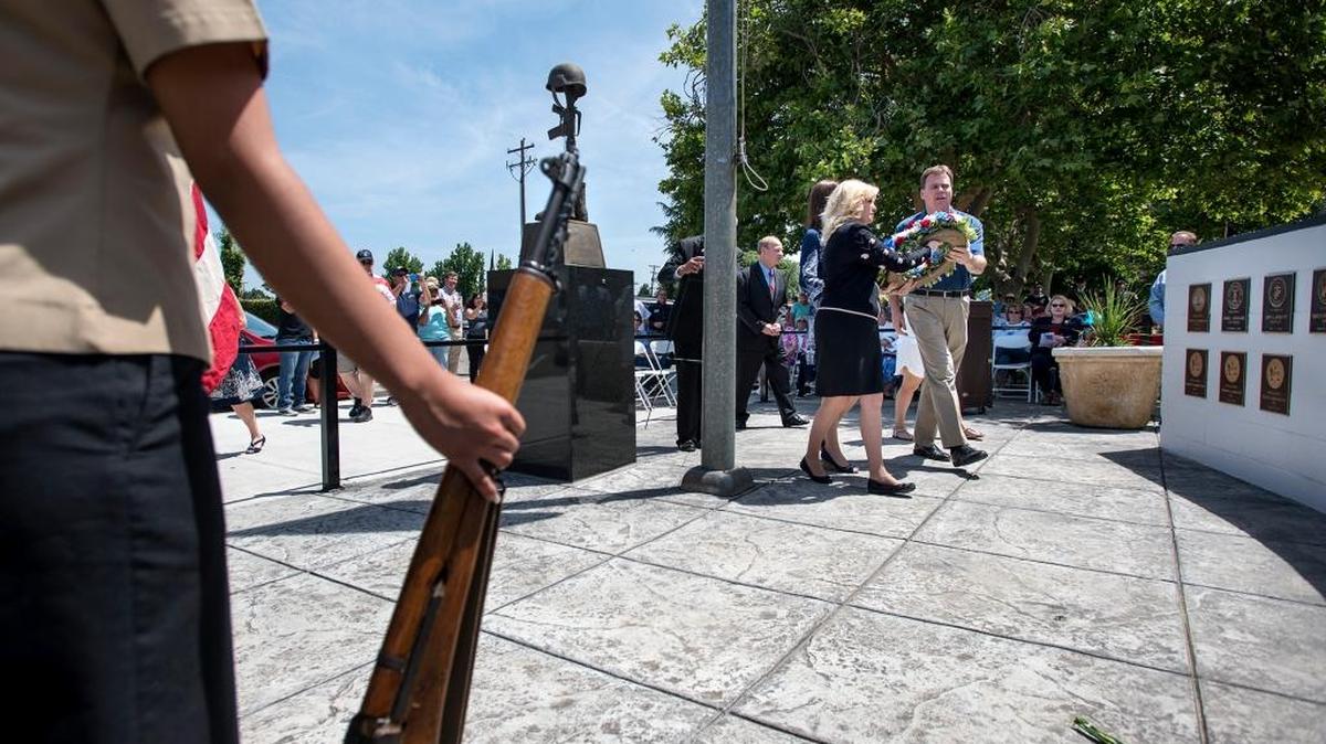 State Sen. Cathleen Galgiani and Stanislaus County Supervisor Bill O'Brien place a wreath on the Veterans Memorial Wall during "A Memorial Day Salute to Our Heroes" in Riverbank, Calif., on Monday, May, 30, 2016.