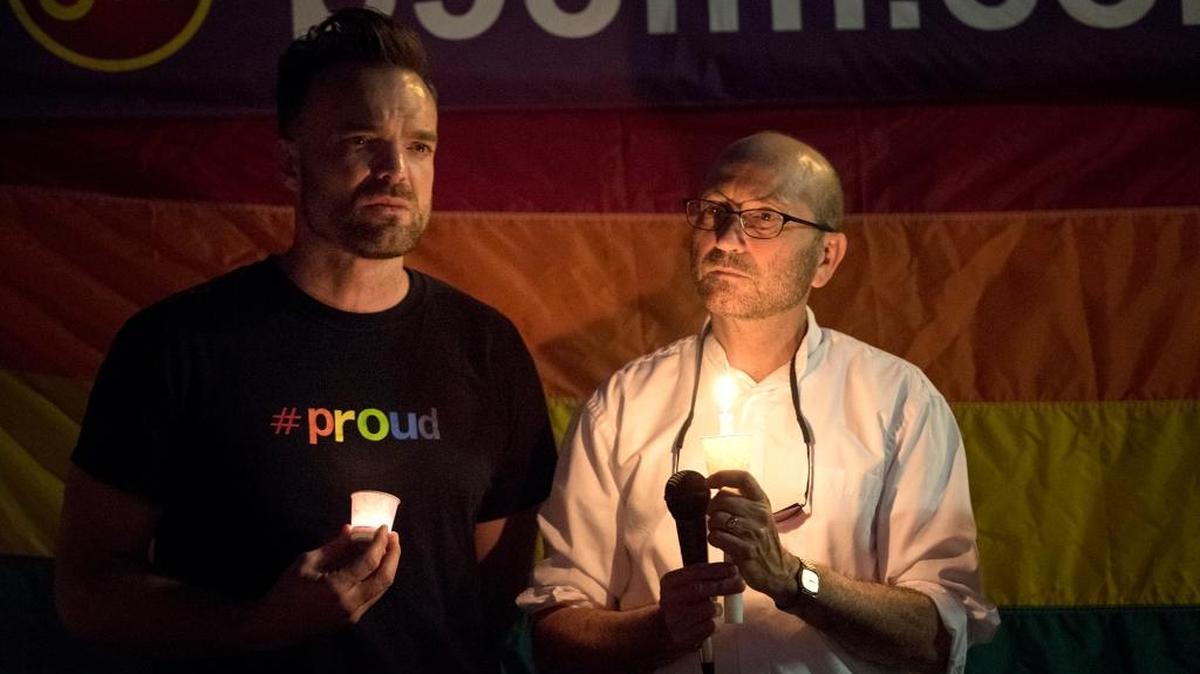 MoPRIDE board member, AndrewThomlison, left, and Rev. Michael Schiefelbein, right, listen as Patty Castillo-Davis sings during a candlelight vigil, organized by MoPRIDE for the victims of the shooting in Orlando at Graceada Park in Modesto, Calif., on Sunday night, June 12, 2016.