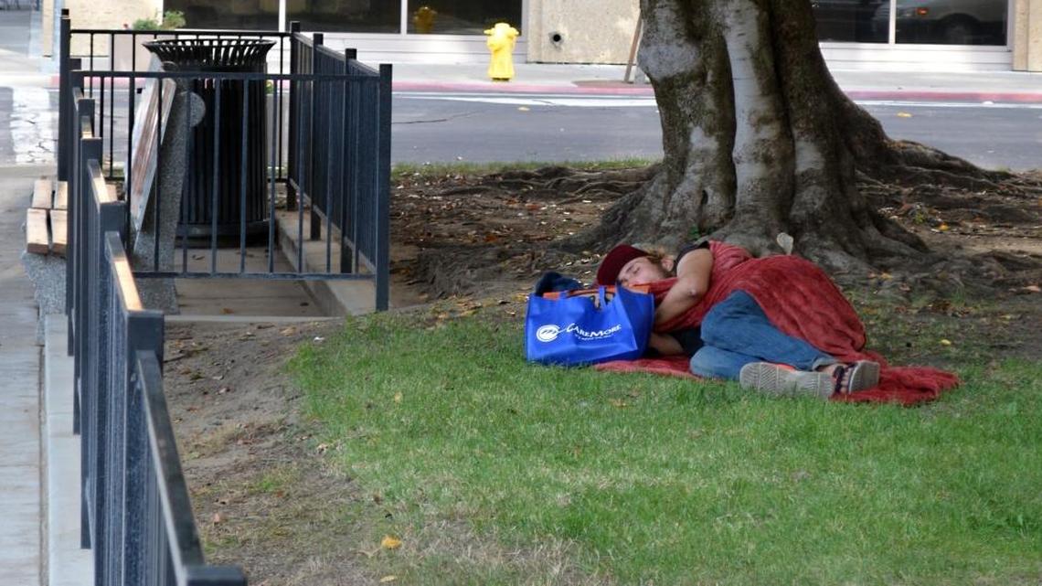 A homeless man sleeps in Stanislaus County Courthouse Park near 12th and I streets in downtown Modesto on Nov. 10.