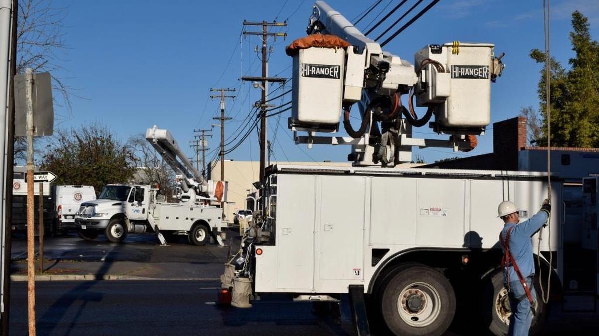 A Modesto Irrigation District crew works on K Street between 11tn and 12th on Monday morning to restore power lost when a tree damaged lines.