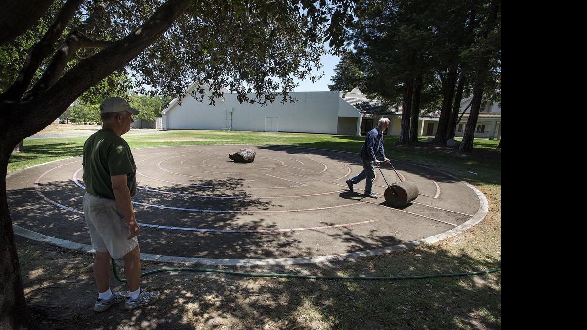 
Bill Johnson, left, and Cal Aukeman, right, put the finishing touch on a spiritual labyrinth at Church of the Brethren in Modesto on Tuesday. The labyrinth was donated by the Couchman family in memory of the their parents, Thelma and Hurley Couchman, and will dedicated May 31.
