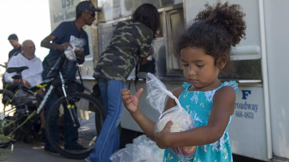 
Aliaha Perez, 3, looks at her lunch during a park feeding by the United Samaritans Foundation’s Modesto lunch truck at James Marshall Park in Modesto on Friday.
