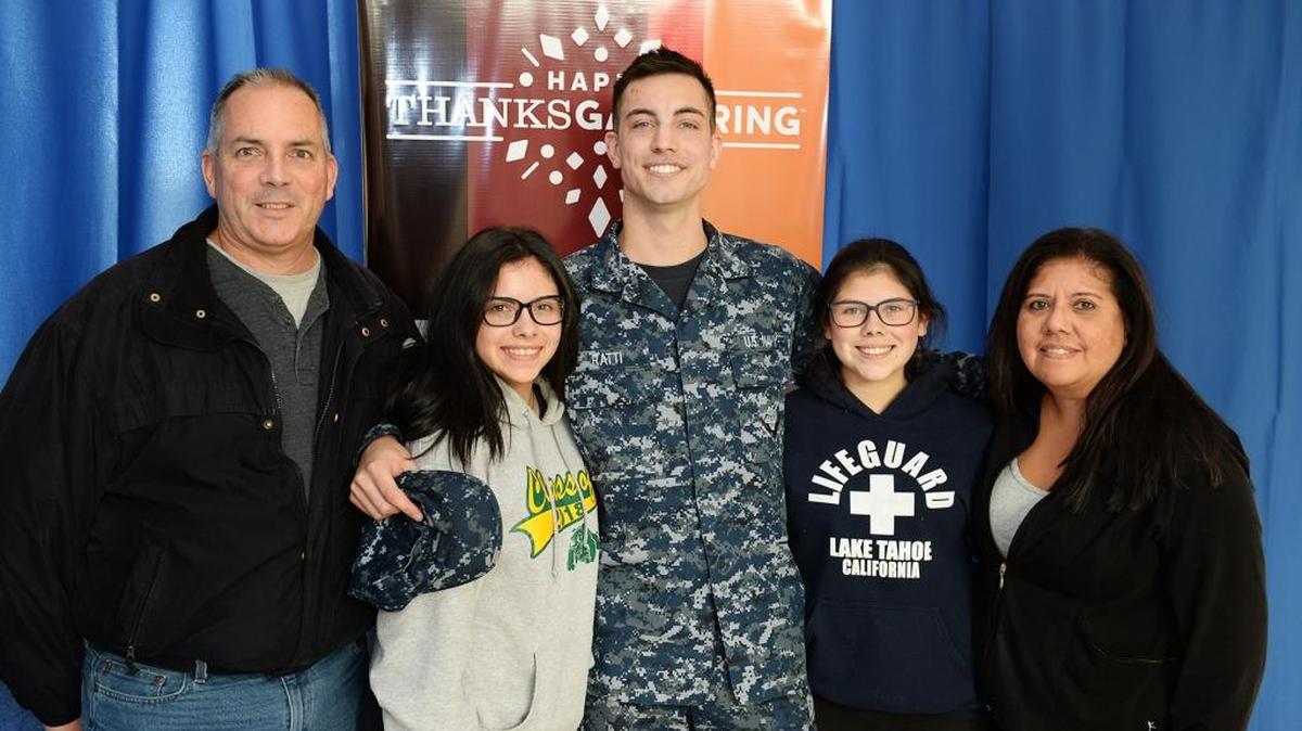 Navy Airman Trevor Ratti of Manteca, center, reunites with, from left, his father, James; sisters Shyanne and Caterina, and mother, Deborah, at Norfolk International Airport before attending the U.S. Navy Morale, Welfare and Recreation ThanksGathering holiday event.