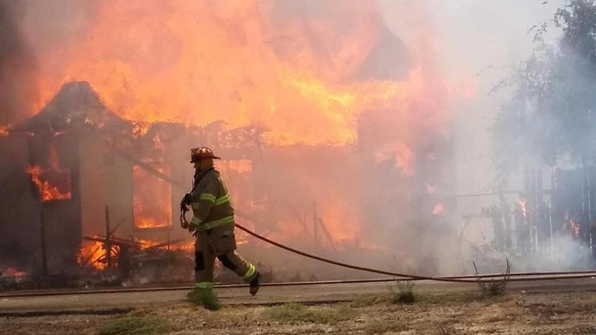 A firefighter battles a blaze in a vacant building near Turlock, California, on Tuesday, July 25, 2017.