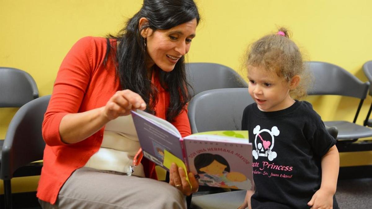 Olga Valencia Cardenas, youth services outreach librarian at the Stanislaus County Library in Modesto, is one of 10 librarians recognized nationally as winners of the I Love My Librarian Award sponsored by the Carnegie Corporation of New York, the New York Library and the New York Times. She received the award in New York on Thursday. She is pictured introducing another child to the wonders of books.