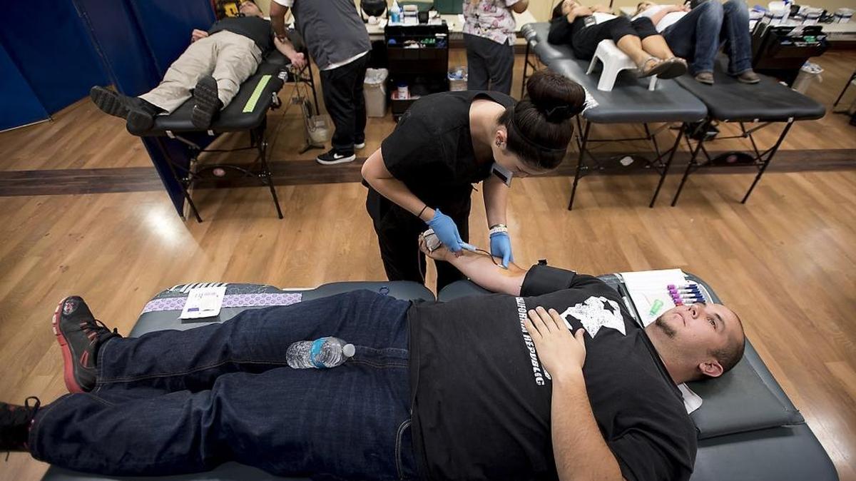 Phlebotomist Sarah Fountain prepares Kyle Spani for a blood donation during the Battle of the Badges blood drive at the Ceres Community Center in Ceres, Calif., on Tuesday, August 23, 2016. The Ceres police and fire departments compete to see who can bring in more blood donors.