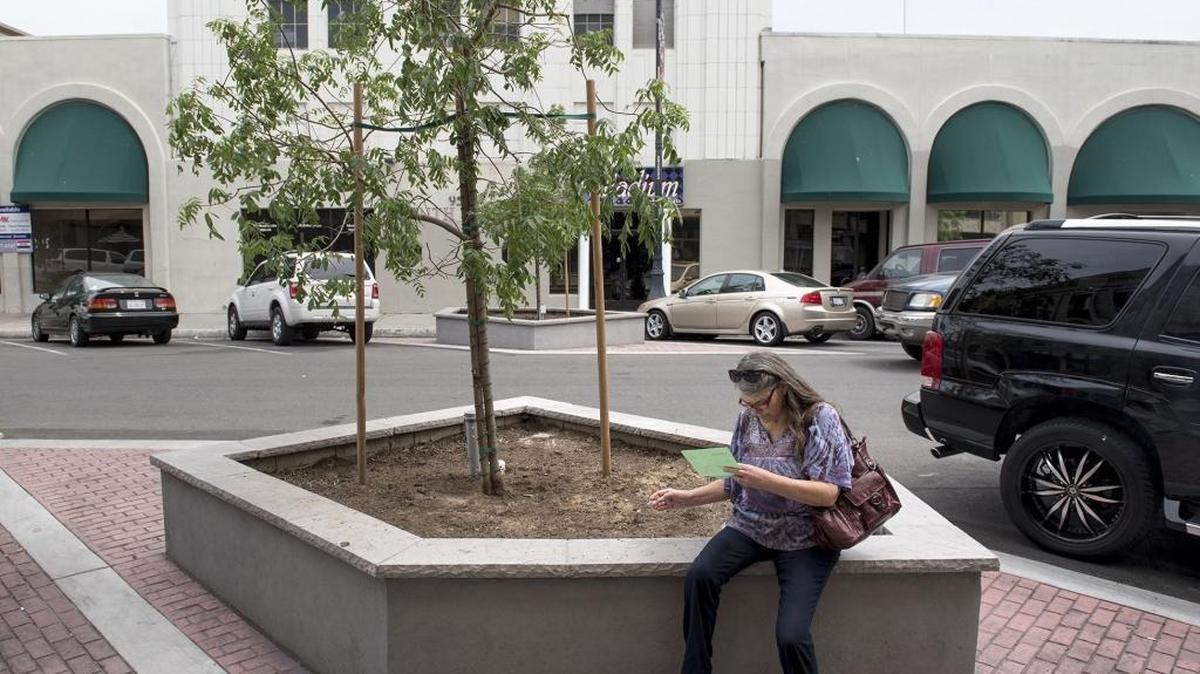Debera Cary takes a break at one of the the newly installed planter boxes along 10th Street in Modesto on Wednesday, May 4, 2016.