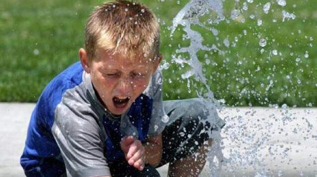 Jacob Prochnow tries to stop the flow of the water fountain at James Marshall Park in 2011.