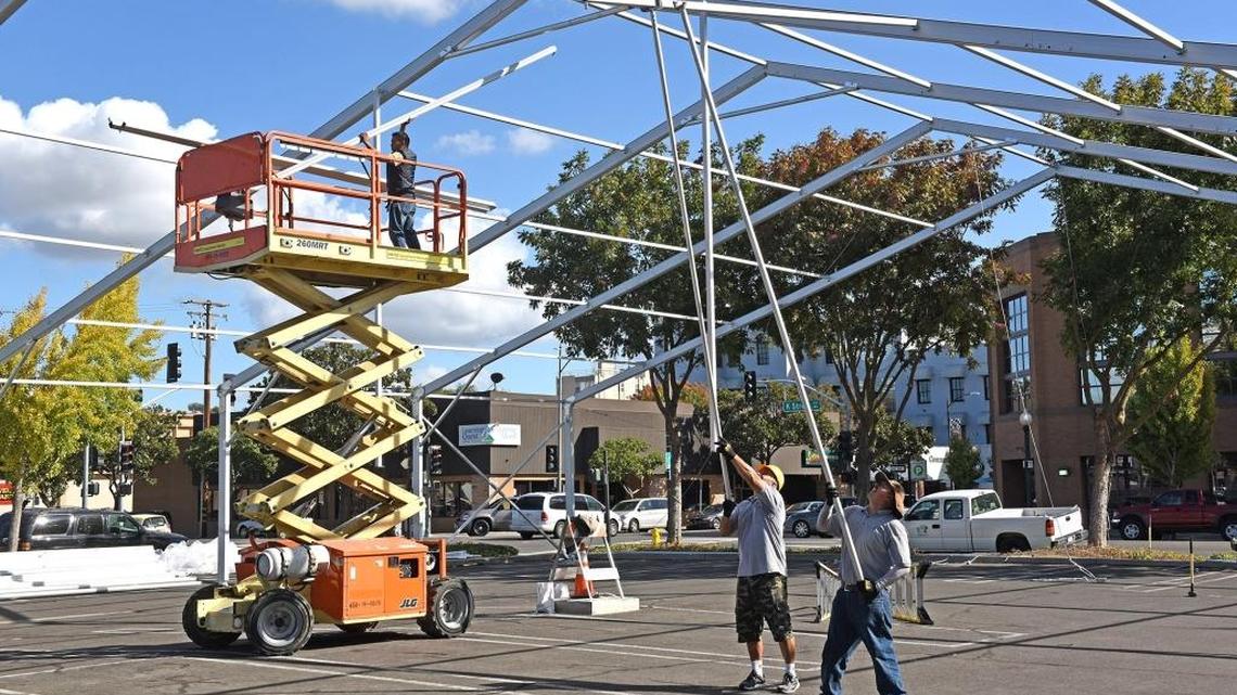 From left to right, Jose Munoz, Oscar Garcia, and Jesus Vasquez with Big Top Rentals construct the metal framework for the tent of Modesto on Ice on Tuesday at the corner of 11th and K streets in downtown Modesto.