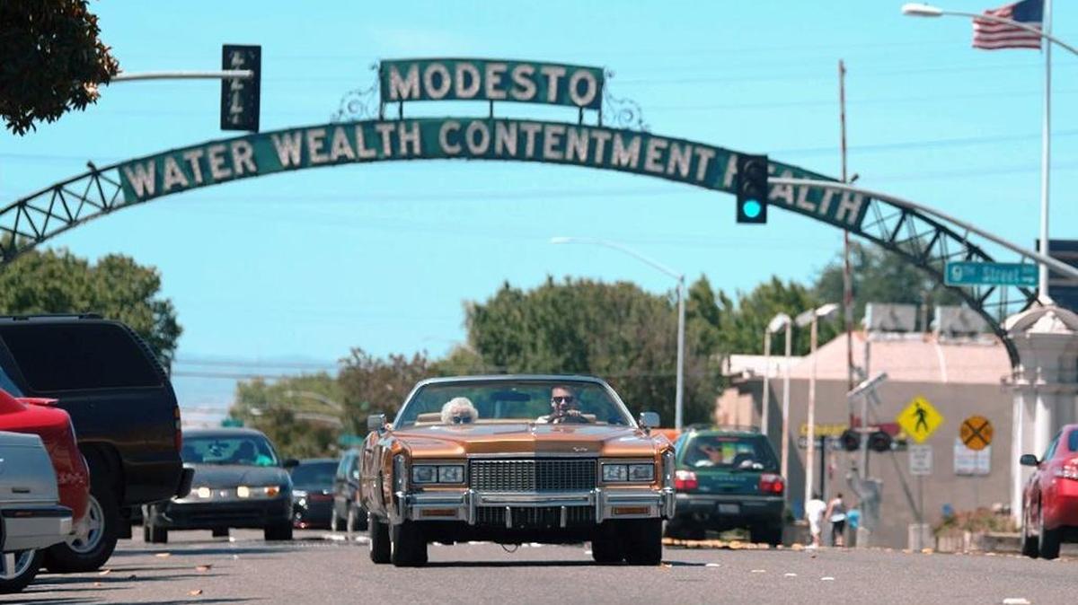 Hip-hop artist Macklemore and his grandmother, Helen Schott, shown driving near the Modesto arch on I street in a still from his music video “Glorious.” The city of Modesto in California is the backdrop for the video, which shows Macklemore spending the day with his grandmother at various locations around town. It was shot over a few days over mid-June.