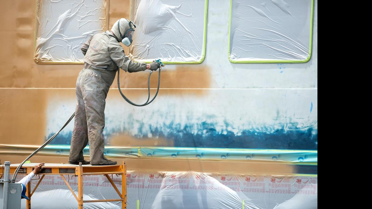 
Dennis Gann from Auto Body Solutions of Modesto paints a dining coach for the Sierra Railroad Co. in Oakdale on Wednesday. The painters have been dealing with surfaces temperatures of the train car as high as 165 degrees.
