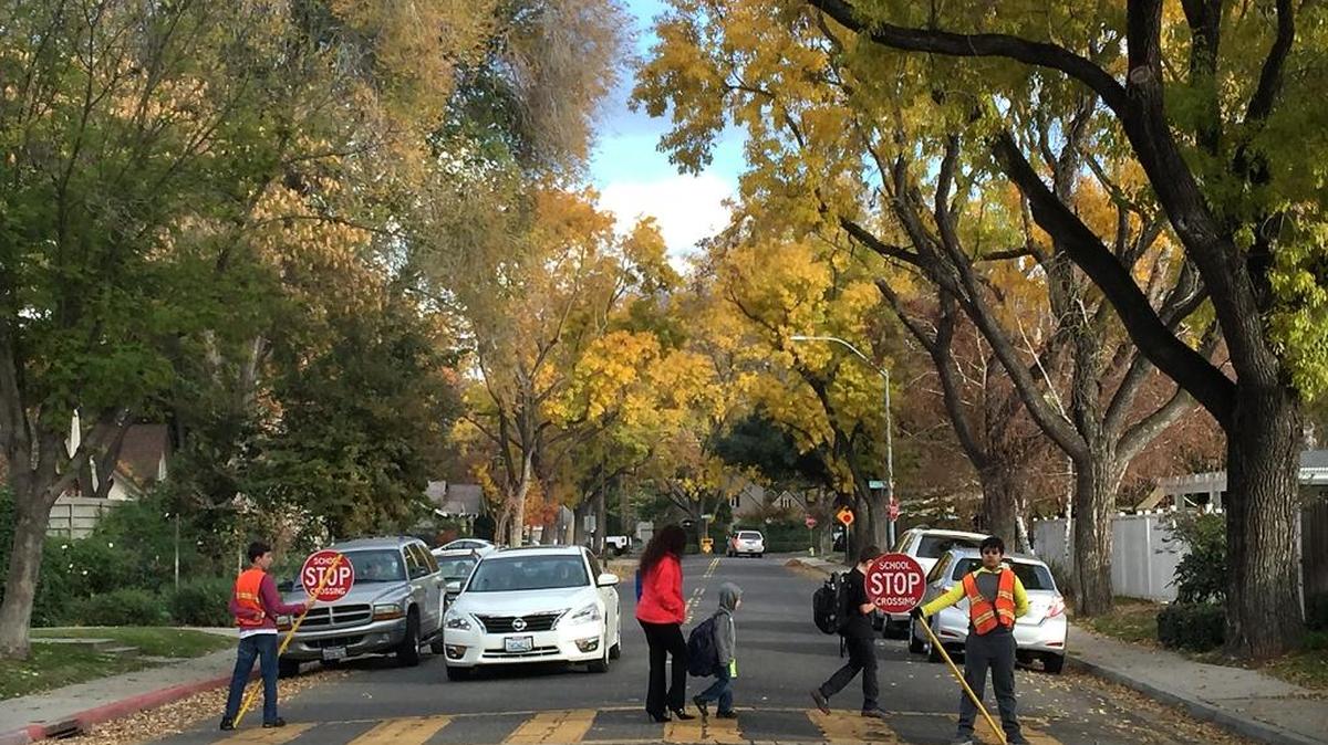 Enslen Elementary School crossing guards cross a parent and students Monday afternoon on Coldwell Avenue near Brady Avenue in Modesto.