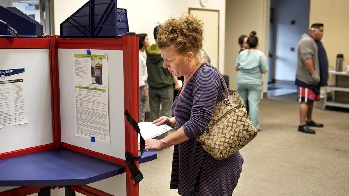 Voter Kathy Mason looks at the ballot as she begins to vote during the general election at Trinity United Presbyterian Church in Modesto on Tuesday.