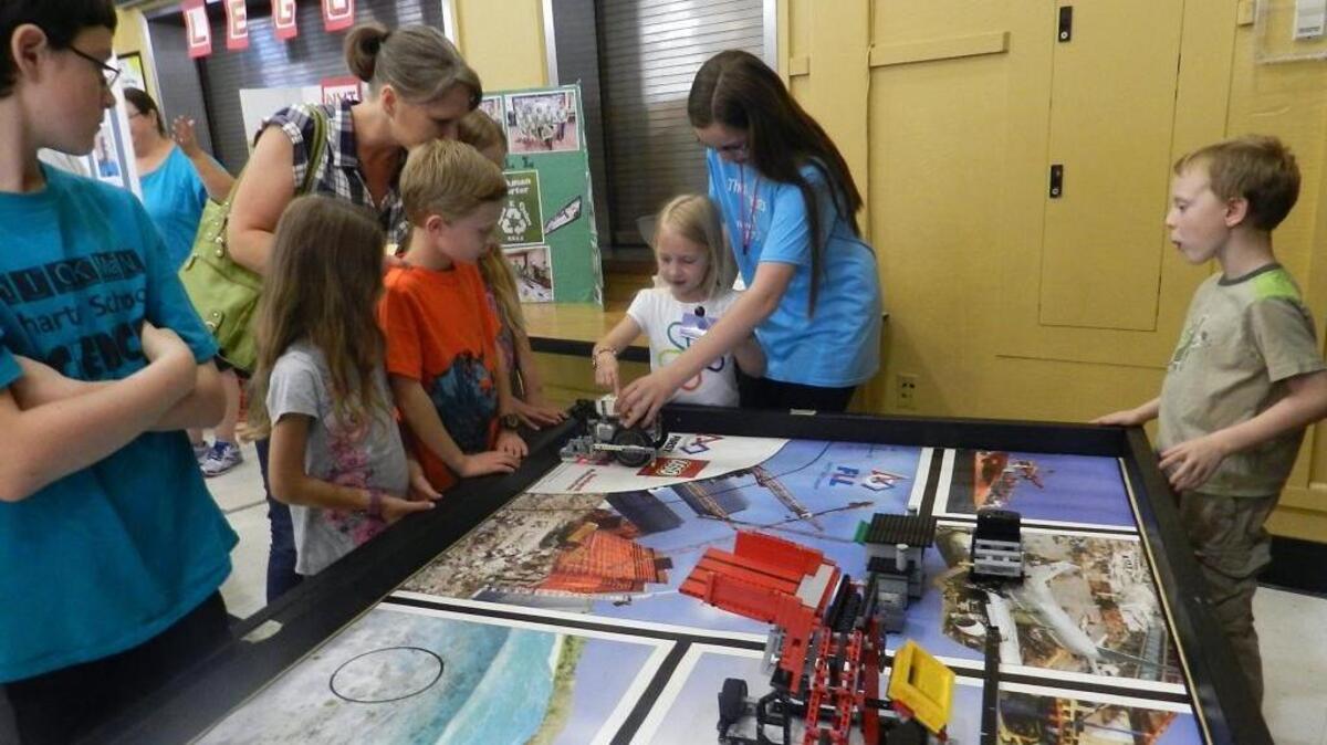 Seventh-grader Katie Osterhout helps youngsters run Lego robots at the Hickman Charter School STEM Maker Faire, a family event that brought together student projects and activities around science, technology, engineering and math. The Maker Hoopla seeks to inspire the same spirit of innovation.