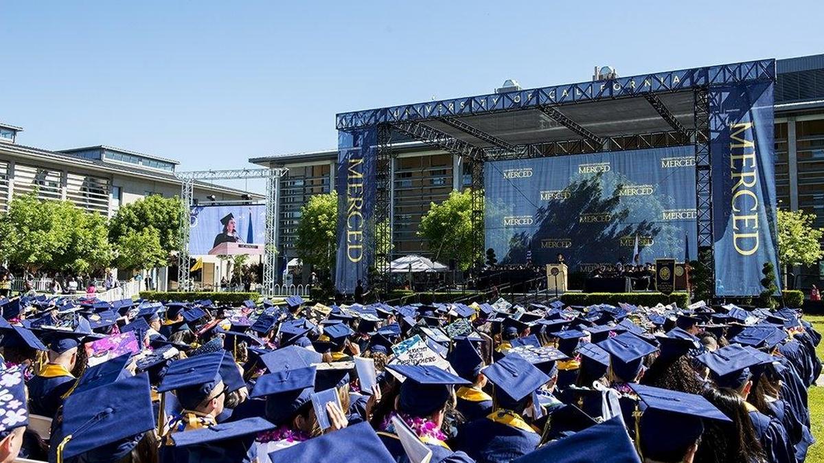 Graduates look on as Maria Cardona, a CNN contributor, delivers the commencement address at the UC Merced School of Social Sciences, Humanities and Arts.