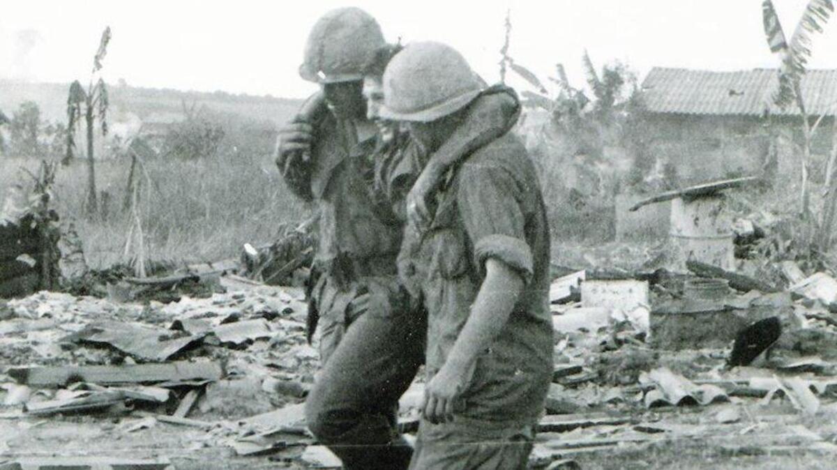 Two soldiers help a wounded comrade to safety during the Tet Offensive on Jan. 31, 1968.