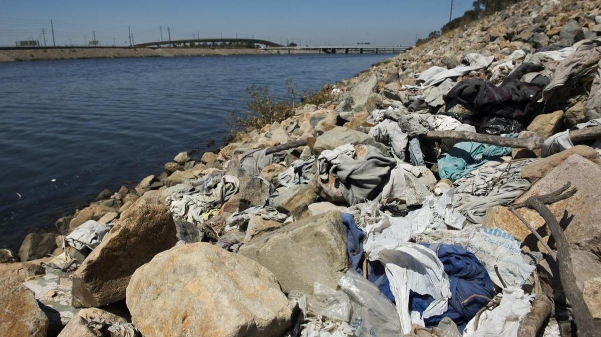 A large pile of washed-up trash, including old plastic bags, sits alongside the Los Angeles River in Long Beach, Calif., on Tuesday, Sept. 2, 2014.