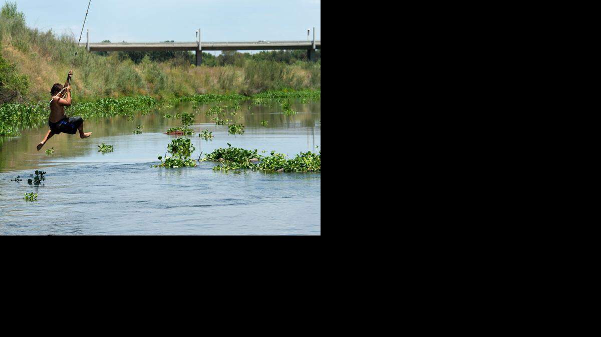 
A 12-year-old boy swings over the Tuolumne River last summer; river flows would be stronger under the state’s proposal, leaving less for irrigation. 
